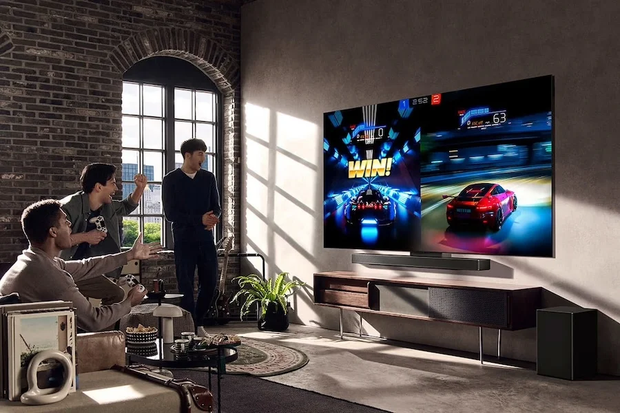 LG SC9S en situation dans un salon avec console de jeu